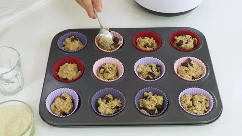 Muffins with dry cranberries. Chef placing muffin batter in silicon cups Stock Footage 130189428