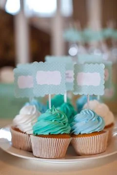 Muffins on a plate decorated with multi-colored cream Stock Photos