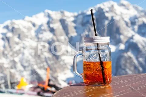 Mug aperol stands on the table of the street cafe on the slope of the ski res Stock Photos