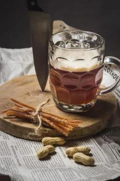 Mug of beer. Dried fish is attached to it. Stock Photos