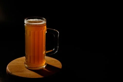 Мug of beer isolated with light in the background.Space for text Stock Photos