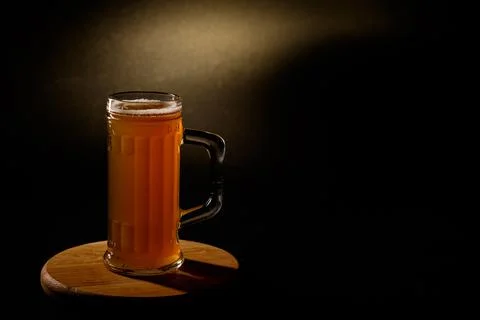 Мug of beer isolated with light in the background.Space for text Stock Photos