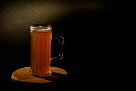 Мug of beer isolated with light in the background.Space for text Stock Photos