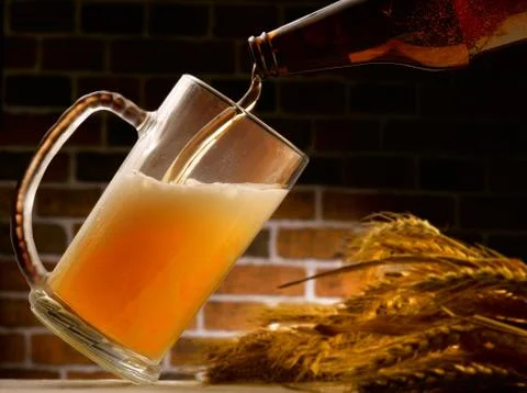 Mug of beer poured in rustic setting Stock Photos