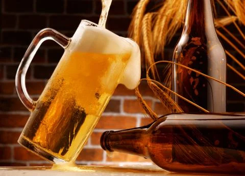 Mug of beer poured in rustic setting Stock Photos