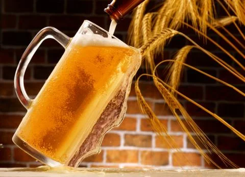 Mug of beer poured in rustic setting Stock Photos