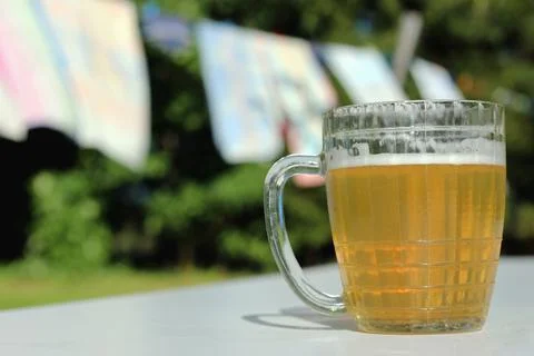 Mug of beer on the table on nature background Stock Photos