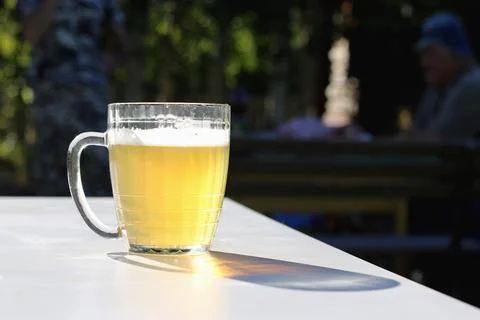 Mug of beer on the table on nature background Stock Photos