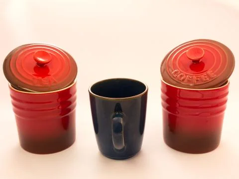 A mug between 2 red jars Stockfoto's