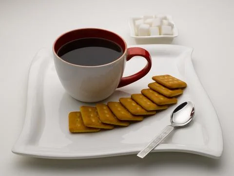 Mug of black tea in serving plate with sugar cubes and biscuits India Foto stock