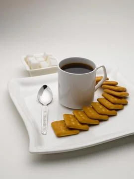 Mug of black tea in serving plate with sugar cubes and biscuits India Stock Photos