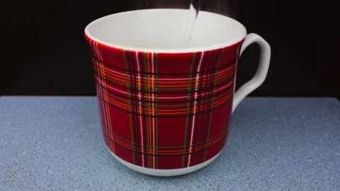 A mug with boiling water on a black background. Boiled water into a mug. Stock Footage 195706536