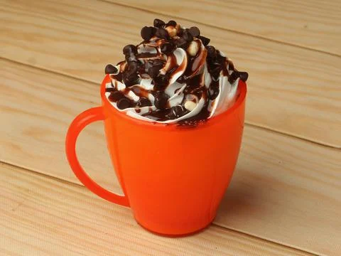Mug cake sprinkled with choco chips on wooden table Stock Photos