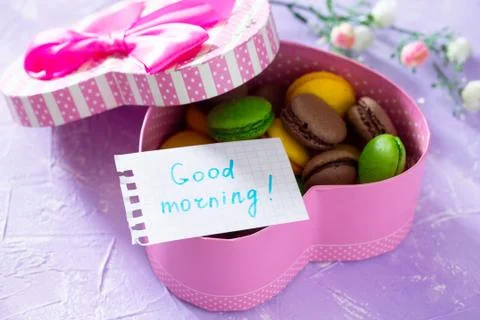 Mug cakes Macaron, leaf notebook inscription good morning on purple table top. Fotos Stock