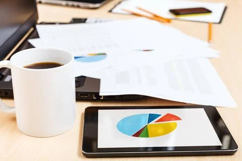 Mug of coffee and tablet pc with chart on desk business workflow - mug of ... Stock Photos