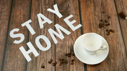 Mug of coffee, coffee beans, and words stay home, coronavirus concept, self h Video stock 128757573