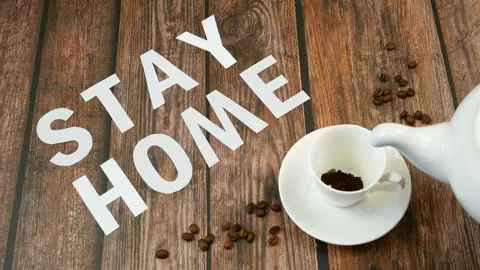 Mug of coffee, coffee beans, and words stay home, coronavirus concept, self h Video stock 128757808