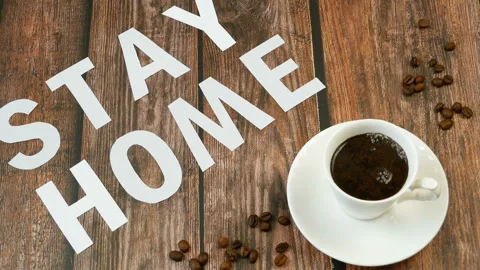 Mug of coffee, coffee beans, and words stay home, coronavirus concept, self h Video stock 128757833