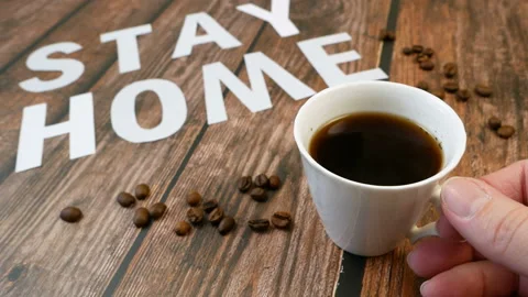 Mug of coffee, coffee beans, and words stay home, coronavirus concept, self h Video stock 129386096