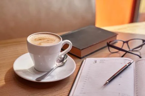 Mug with coffee on a diary with glasses Stock Photos
