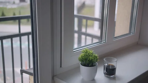 A mug of coffee is on the windowsill, outside the window there is traffic Stock Footage 158763558