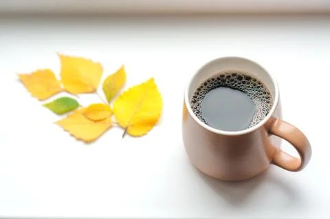 A mug with coffee is on the windowsill Stock Photos