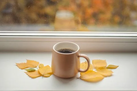 Mug with coffee on the windowsill Stock Photos