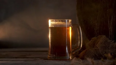 Mug with fresh light beer with foam on wooden vintage background with barrel Stock Footage 167055249