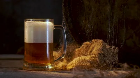 Mug with fresh light beer with foam on wooden vintage background with barrel Stock Footage 167055309