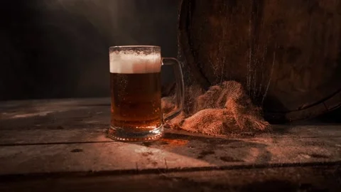Mug with fresh light beer with foam on wooden vintage background with barrel Stock Footage 167055484