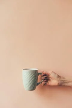 Mug in hand on a blank background Foto stock