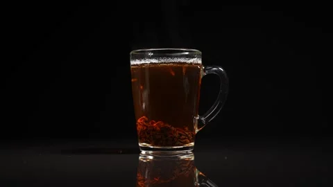 Mug with hot black tea on the table on a black background Video stock 253326478