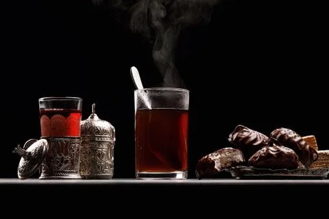 Mug with hot tea from which there is steam, on a dark background with marshma Stock Photos