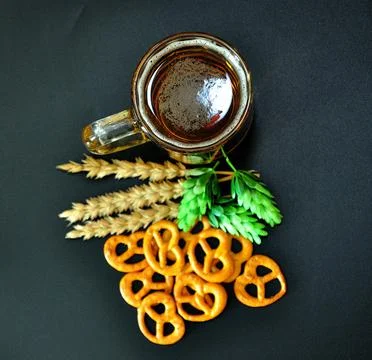 A mug of light beer, next to it are ears of corn, ripe hops and a bunch of sa Stock Photos