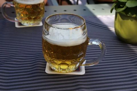 Mug of light beer stands on the table Stock Photos