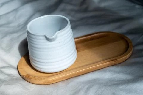 Mug made of white clay or ceramic mug on the wooden plate, the cloth backgrou Stock Photos