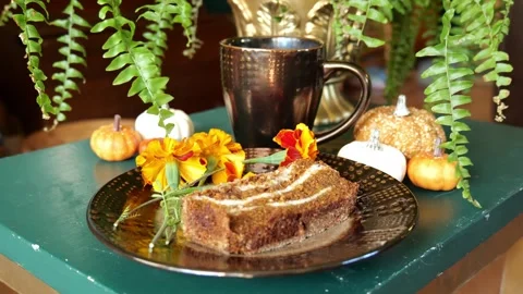 A Mug of Pumpkin Spice Latte Sitting on a Table with a Slice of Bread 4K Video stock 317312761