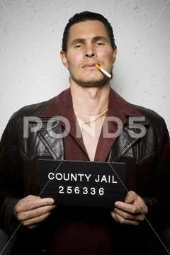Mug shot of man with cigarette and gold chains Stock Photos