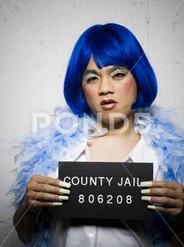 Mug Shot Of Man In Drag With Blue Wig And Feather Boa