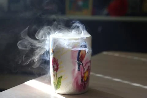 Mug with smoke on a table Stock Photos