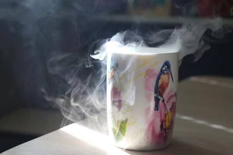 Mug with smoke on a table Stock Photos