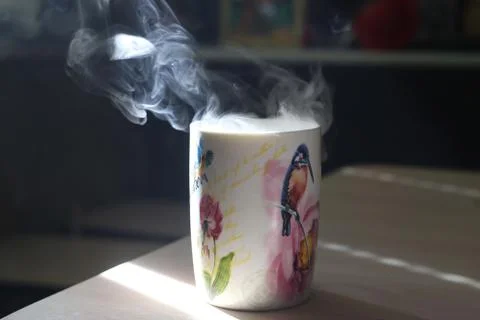 Mug with smoke on a table Stock Photos