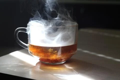 Mug with smoke on a table Stock Photos