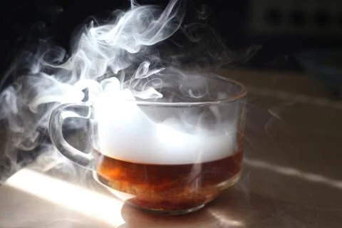 Mug with smoke on a table Stock Photos