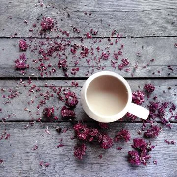 Mug of tea surrounded by dried flower blossoms Stock Photos