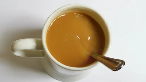 Mug of tea with teaspoon stirring by itself as if by magic. invisible person. Stock Footage 125518583