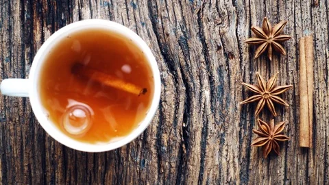 A mug of tea on a textured table with cinnamon and star anise. Stock Footage 116129521