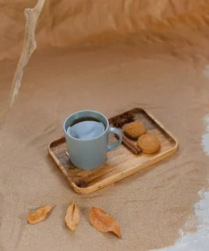 A mug of tea on a wooden tray, next to homemade cookies and spices. Background Foto stock