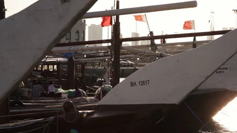 Muharraq Port. Dhows at sunset with Bahrain Flags and Fishermen Video stock 73685331