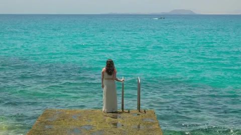 Mujer al final de un embarcadero contempla el color turquesa del mar 動画素材 158237175